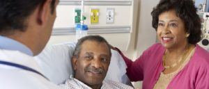 Doctor Talking To Senior Couple On Ward