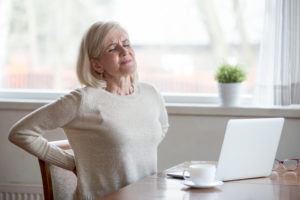 Woman feels back pain massaging aching muscles