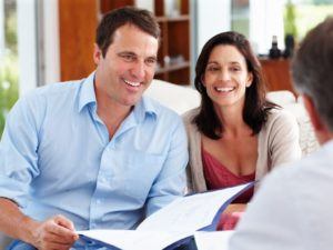 Couple reviewing paperwork and speaking with doctor