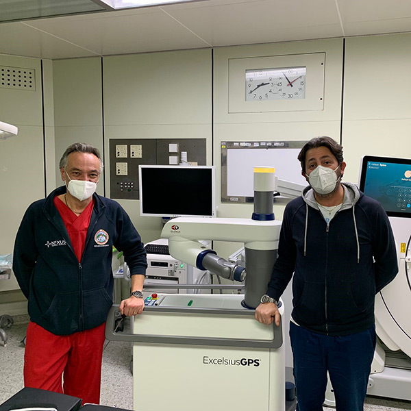 Surgeons standing in front of ExcelsiusGPS robot